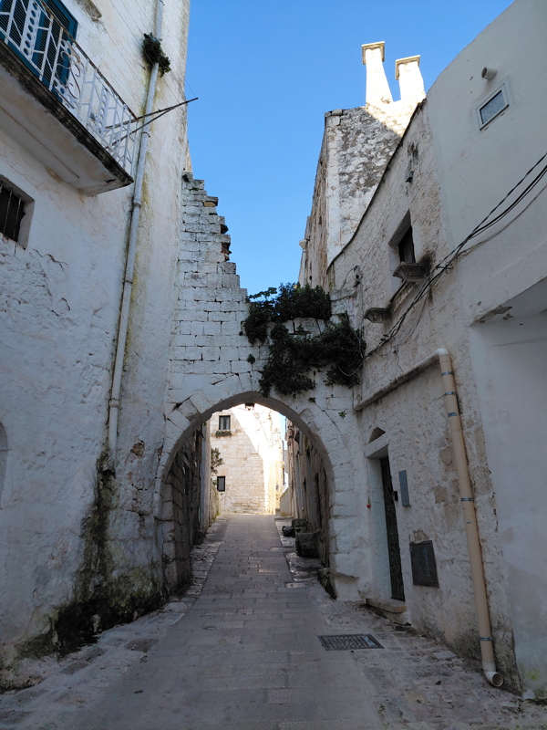 Narrow, whitewashed alleyway in the historic old town of Ostuni, Italy